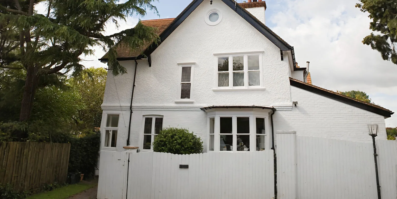 White rendered house with a gabled roof and white windows